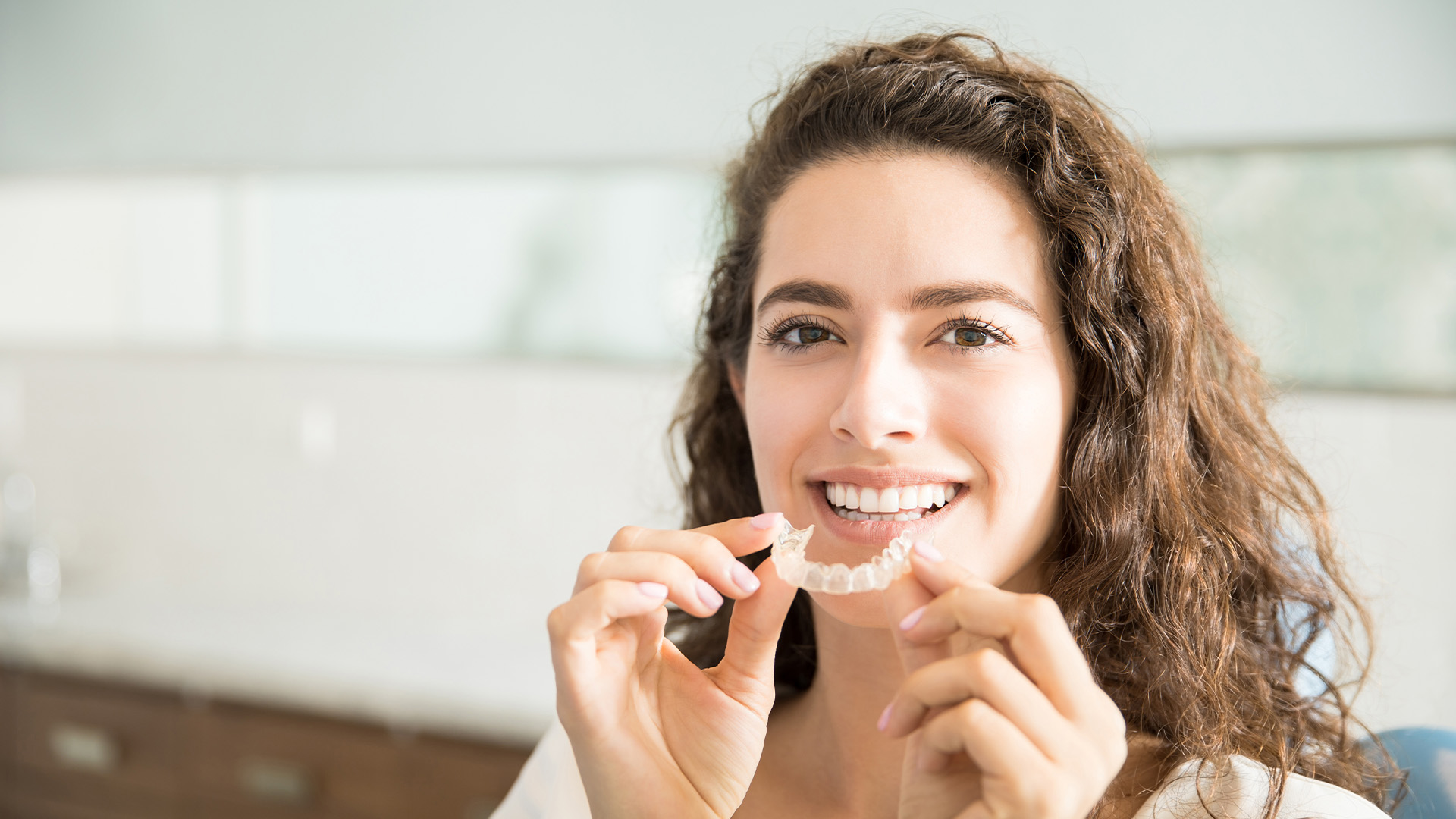 Clear Aligners Kalamazoo Mi Dentist Patient holding a clear aligner